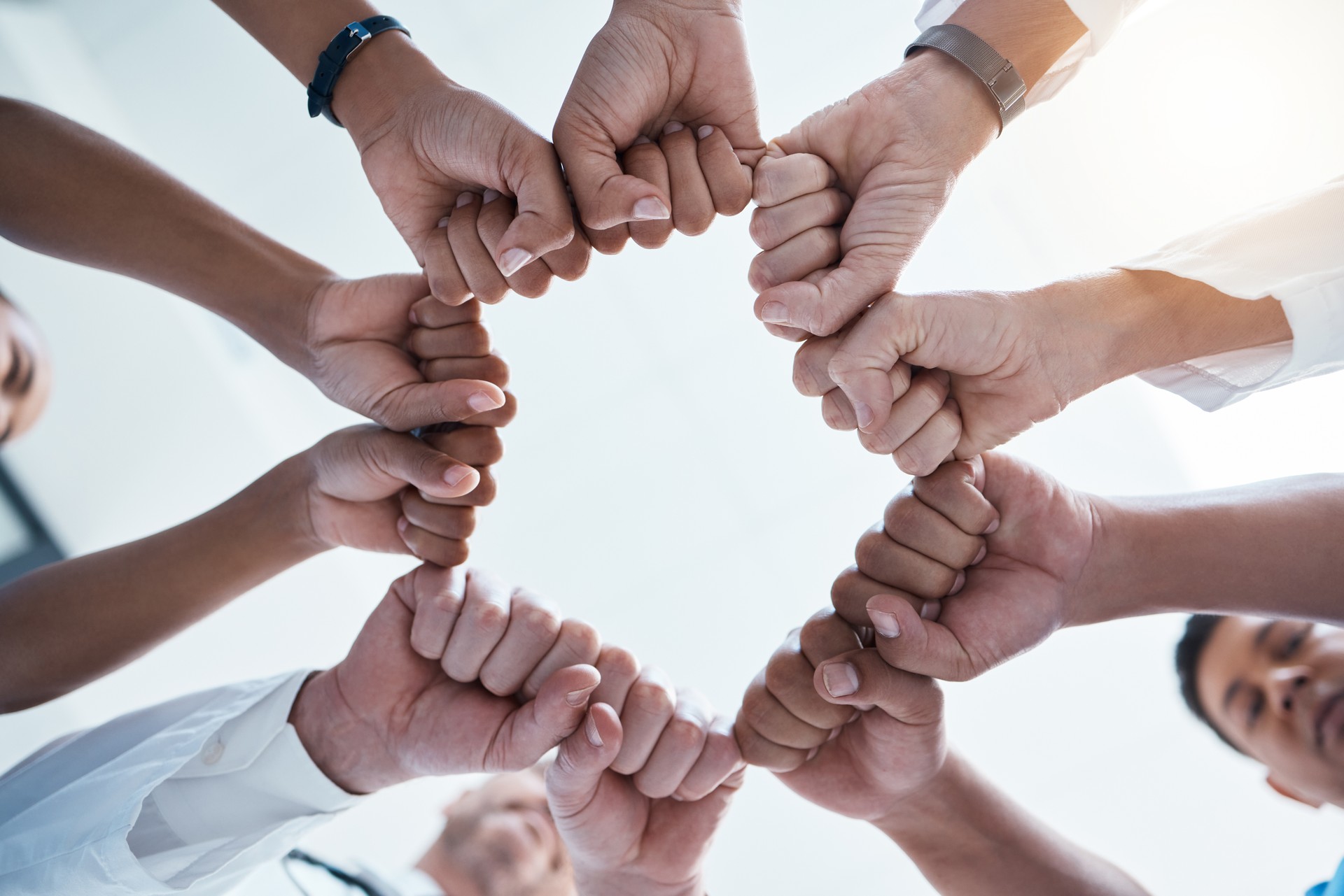 Corporate diversity, teamwork and fist in circle of group of business employees at office team building motivation event. Staff collaboration, professional community and fist bump to support mission